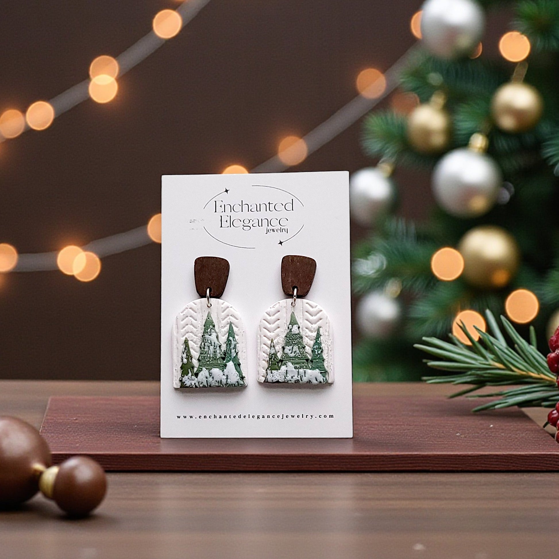 Earring card with Christmas tree design on a wooden surface with festive decorations.